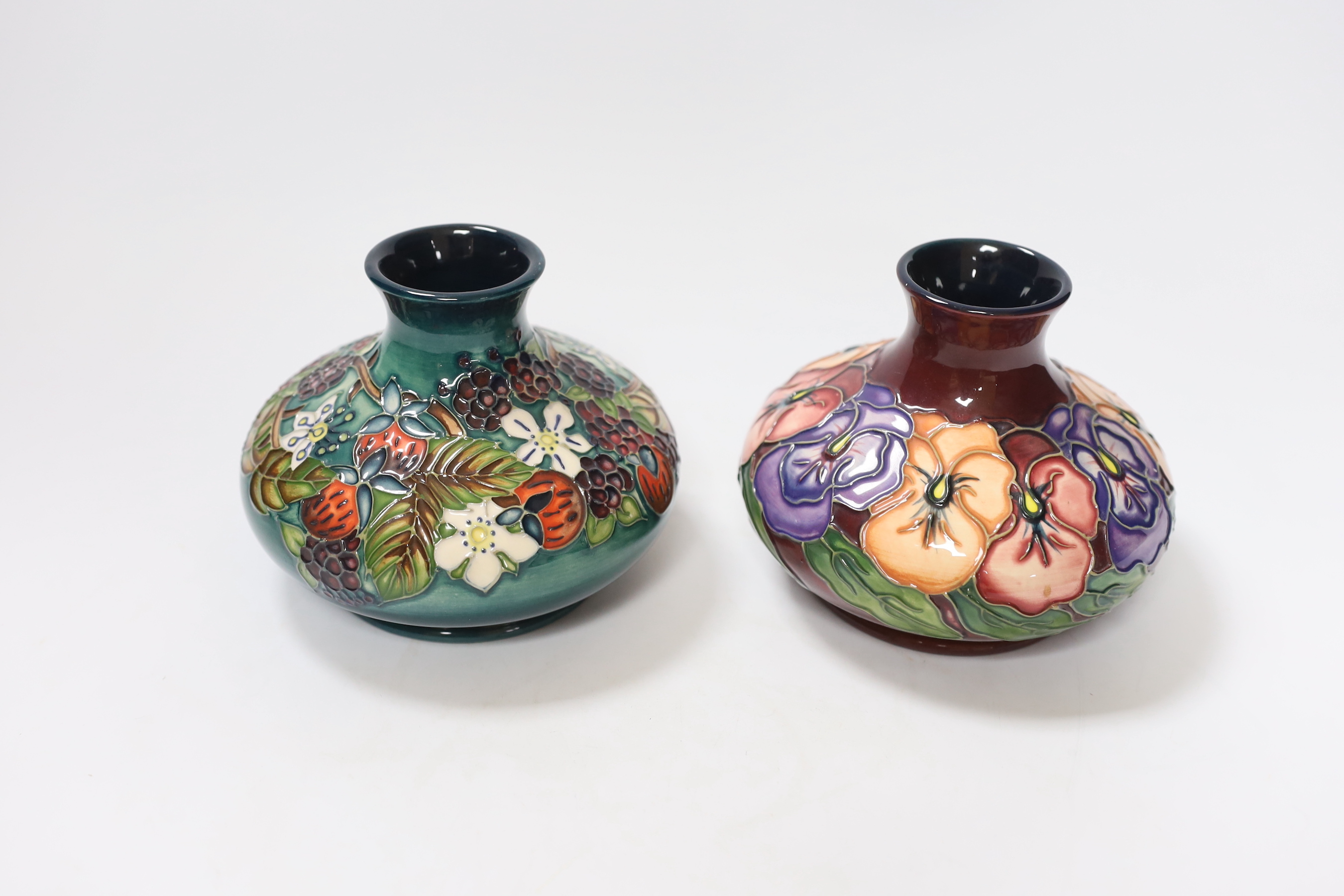 Two small Moorcroft squat vases, in Pansy and Carousel patterns, 10.5cm